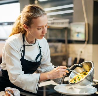 female-chef-pouring-food-plate